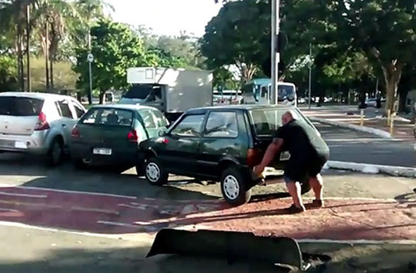 Homem usa as mãos para tirar carro de ciclovia / Foto: Reprodução YouTube